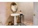 Chic powder room with pedestal sink, decorative mirror, and hardwood floors at 1 Silver Fox Dr, Greenwood Village, CO 80121