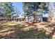 Large backyard with mature trees, a patio, and a storage shed, offering ample space for outdoor activities at 13000 Willow Ln, Golden, CO 80401