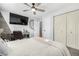 Well-lit bedroom with a ceiling fan, closet, desk, and attached TV for relaxing comfort and style at 13000 Willow Ln, Golden, CO 80401