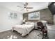 Bedroom with a wood accent wall, a comfortable bed, a ceiling fan, and windows for natural light at 13000 Willow Ln, Golden, CO 80401