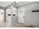 Bright entryway featuring tiled floors, coat hooks, a modern light fixture, and views into the kitchen at 13000 Willow Ln, Golden, CO 80401