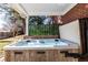 Relaxing hot tub on a covered patio with views of the backyard, surrounded by privacy greenery at 13000 Willow Ln, Golden, CO 80401