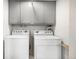 Functional laundry room equipped with a washer, a dryer, and convenient overhead cabinets for ample storage space at 13000 Willow Ln, Golden, CO 80401