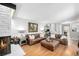 Bright living room with hardwood floors, a stone fireplace, and comfortable leather seating, perfect for relaxation at 13000 Willow Ln, Golden, CO 80401