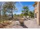 Expansive back deck provides outdoor seating with views of mature trees and blue skies at 19595 E Top O The Moor Dr, Monument, CO 80132