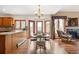 Cozy dining area with a table set for six, fireplace, hardwood floors, and abundant natural light at 19595 E Top O The Moor Dr, Monument, CO 80132