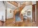 Grand foyer featuring a curved staircase with wood banisters and hardwood flooring at 19595 E Top O The Moor Dr, Monument, CO 80132