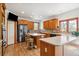 Bright kitchen with stainless steel appliances, wood cabinetry, and a central island with seating at 19595 E Top O The Moor Dr, Monument, CO 80132