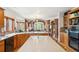 Open kitchen with wood cabinets, countertops, and barstool seating that adjoins the Gathering room at 19595 E Top O The Moor Dr, Monument, CO 80132