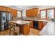 Functional kitchen with wood cabinetry, stainless steel appliances, an island with seating and neutral countertops at 19595 E Top O The Moor Dr, Monument, CO 80132