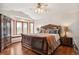 Main bedroom with hardwood flooring, ceiling fan, and natural light from a large bay window overlooking the trees at 19595 E Top O The Moor Dr, Monument, CO 80132