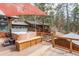 Relaxing back deck featuring a hot tub, wooden bench, and shade for ultimate outdoor comfort at 27407 Upper Cold Spg Gulch Rd, Golden, CO 80401