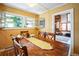 Bright dining room features an antique table with seating and a garden view through awning style windows at 27407 Upper Cold Spg Gulch Rd, Golden, CO 80401