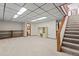 Finished basement area with carpeting, drop ceiling, and stairs, perfect for entertainment and relaxation at 7351 Poppy Way, Arvada, CO 80007