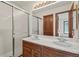 Bathroom featuring double sinks, a walk-in shower with glass doors and tile surround at 7351 Poppy Way, Arvada, CO 80007