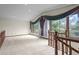 A spacious living room with large windows offering views of the surrounding trees and greenery at 7351 Poppy Way, Arvada, CO 80007