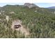 Aerial view showcasing the home nestled among evergreen trees and natural rock formations at 5976 Stone Creek Dr, Evergreen, CO 80439