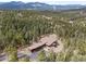Expansive aerial view of a luxury home surrounded by dense forest and mountain views at 5976 Stone Creek Dr, Evergreen, CO 80439