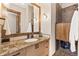 Bathroom with a granite counter, wood cabinets, and a tiled shower with wood door at 5976 Stone Creek Dr, Evergreen, CO 80439