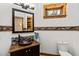 Updated bathroom with stained glass window, copper sink and dark wood cabinets at 5976 Stone Creek Dr, Evergreen, CO 80439