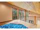 Upper level loft space with wood paneled ceiling, large windows offering outdoor views, and a ceiling fan at 5976 Stone Creek Dr, Evergreen, CO 80439