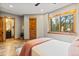 Bright bedroom with wooden doorframes, a view to the green outdoors, and a door to the bathroom at 5976 Stone Creek Dr, Evergreen, CO 80439