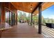 Expansive deck with outdoor seating, wood railings, and beautiful mountain views at 5976 Stone Creek Dr, Evergreen, CO 80439