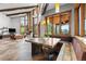 Open-concept dining area with custom wood table, banquette seating, and floor-to-ceiling windows overlooking the mountain view at 5976 Stone Creek Dr, Evergreen, CO 80439