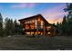 Two-story rustic modern home with balconies, a fire pit, and large windows overlooking a wooded lot at 5976 Stone Creek Dr, Evergreen, CO 80439
