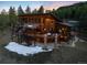 Stunning exterior view of a custom-built home surrounded by trees at dusk at 5976 Stone Creek Dr, Evergreen, CO 80439