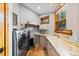Spacious laundry room features modern washer, dryer, stylish sink, and wooden framed window at 5976 Stone Creek Dr, Evergreen, CO 80439