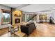 Cozy living room with stone fireplace, plush sofa, and windows offering scenic views, adjacent exercise area at 5976 Stone Creek Dr, Evergreen, CO 80439