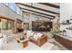 Open-concept living area with tall ceilings, exposed beams, and seamless flow to kitchen and dining at 5976 Stone Creek Dr, Evergreen, CO 80439