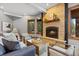 Inviting living room featuring a stone fireplace, wood accents, comfortable seating, and natural light at 5976 Stone Creek Dr, Evergreen, CO 80439