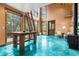 Cozy living area with large windows, wooden ladder, unique blue flooring and a wood-burning stove at 5976 Stone Creek Dr, Evergreen, CO 80439