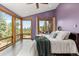 Bright main bedroom with floor to ceiling windows, private balcony access, and mountain views at 5976 Stone Creek Dr, Evergreen, CO 80439
