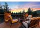 Relaxing patio with comfortable seating around a fire pit, showcasing stunning views and a colorful sunset at 5976 Stone Creek Dr, Evergreen, CO 80439
