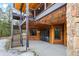 Exterior patio area featuring a staircase, wood paneling, and sliding glass doors to the interior at 5976 Stone Creek Dr, Evergreen, CO 80439