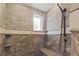 Updated tile shower with stone bench seating and a hand held shower head at 5976 Stone Creek Dr, Evergreen, CO 80439