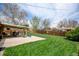 Well-manicured backyard featuring a covered patio, spacious lawn, and a privacy fence at 6020 Quail St, Arvada, CO 80004