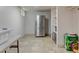 Clean, unfinished basement area with a stainless steel refrigerator, shelving, and tiled flooring at 6020 Quail St, Arvada, CO 80004