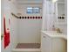 Bathroom featuring tiled shower, classic vanity, black and white tiled flooring, and decorative diamond accents at 6020 Quail St, Arvada, CO 80004