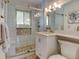 Modern bathroom with a glass shower, white vanity with granite countertops, and updated lighting at 6020 Quail St, Arvada, CO 80004