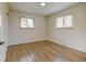Empty bedroom with wood floors, two windows, and fresh paint at 6020 Quail St, Arvada, CO 80004