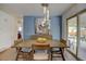 The dining area features stylish lighting, a statement wall color, and outdoor patio access at 6020 Quail St, Arvada, CO 80004