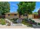 Charming brick home featuring a beautifully landscaped front yard and brick walkway to a red front door at 6020 Quail St, Arvada, CO 80004