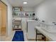 Bright laundry room with a washer and dryer, shelving for storage, and ample counter space at 6020 Quail St, Arvada, CO 80004