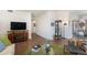 Living room with wood floors, neutral walls, stylish decor, and a large television at 7250 Eastmoor Dr # 203, Denver, CO 80237
