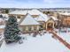 Luxury home with snow covered landscaping, mountain views, and stone accents at 774 Chamberlain Way, Highlands Ranch, CO 80126