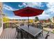 Deck with table, chairs, and umbrella overlooking landscape at 774 Chamberlain Way, Highlands Ranch, CO 80126